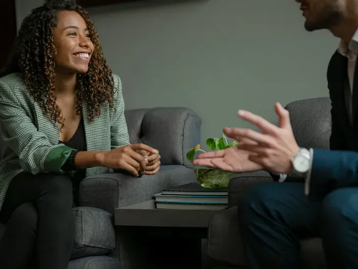 Two business professionals sitting and talking during a consultation meeting in a modern office on localservicelistingnow.com